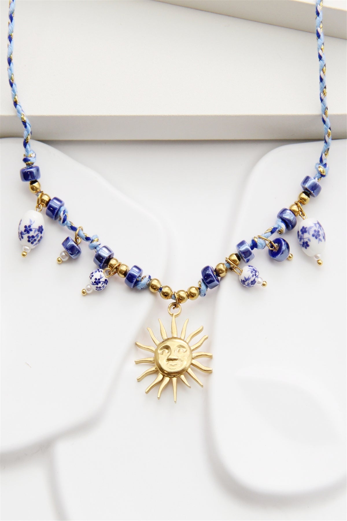 Collier cordon tressé perles bleues soleil doré
