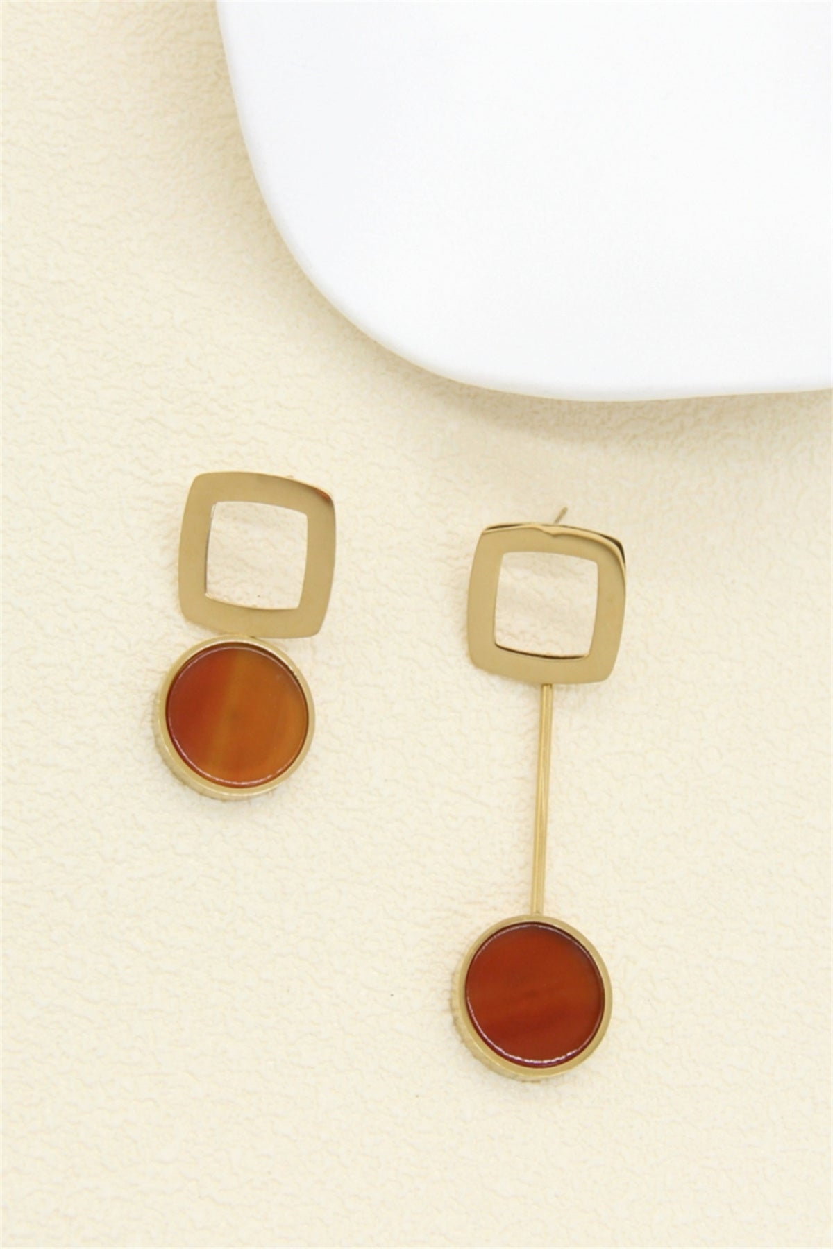Boucles d'oreilles asymétriques dorées carré ajouré et pierre rouge orangé