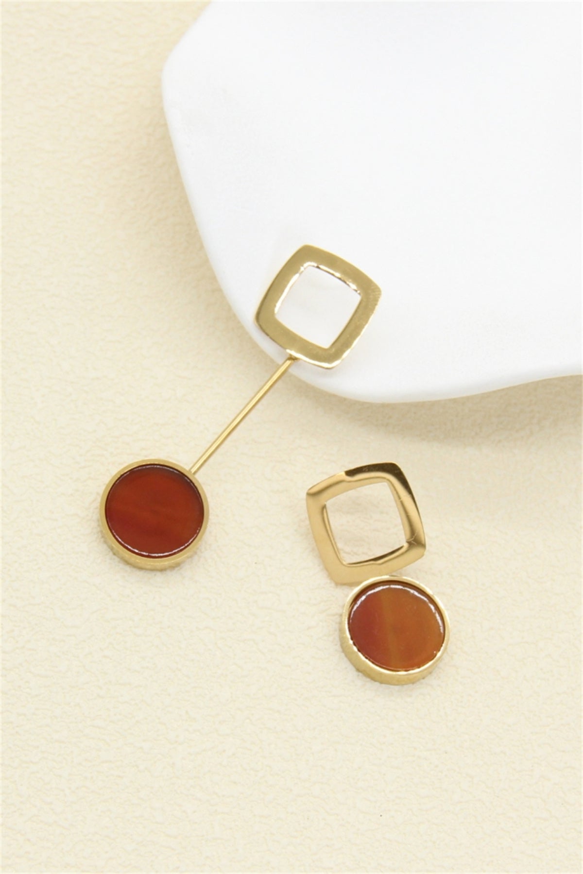 Boucles d'oreilles asymétriques dorées carré ajouré et pierre rouge orangé