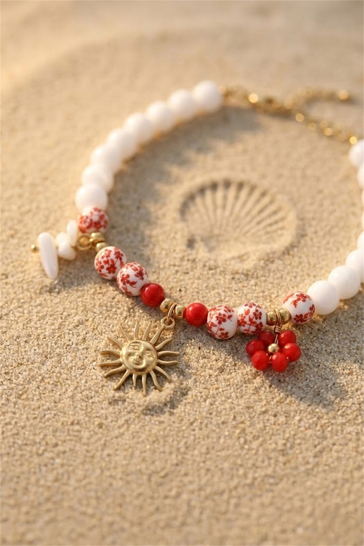 Bracelet perles blanches et fleuries rouges charm soleil doré