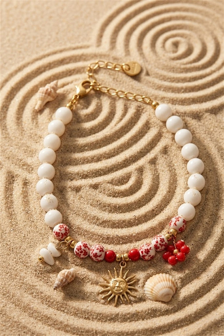 Bracelet perles blanches et fleuries rouges charm soleil doré