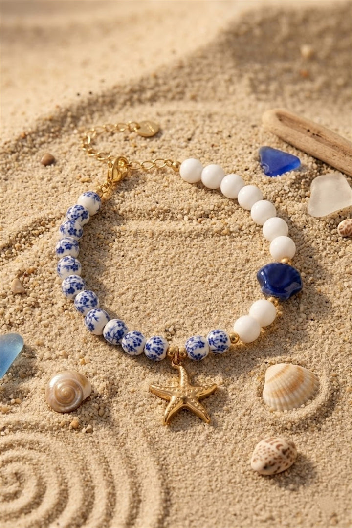Bracelet perles blanc et bleu fleuri charm étoile de mer dorée