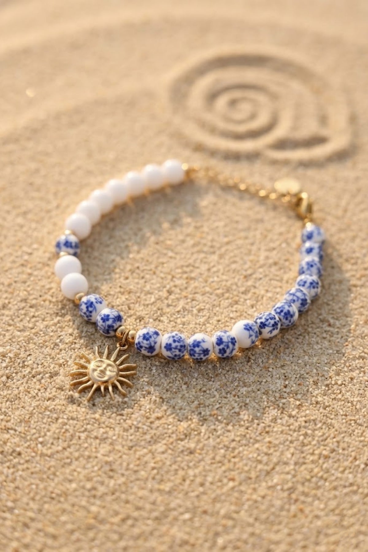 Bracelet perles asymétrique blanc et bleu fleuri pendentif soleil doré