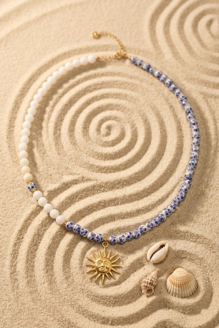 Collier perles asymétrique blanc et bleu fleuri pendentif soleil doré