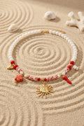 Collier perles blanches et rouges charms soleil doré