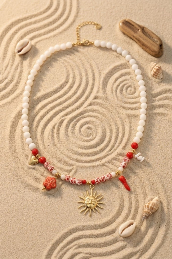 Collier perles blanches et rouges charms soleil doré