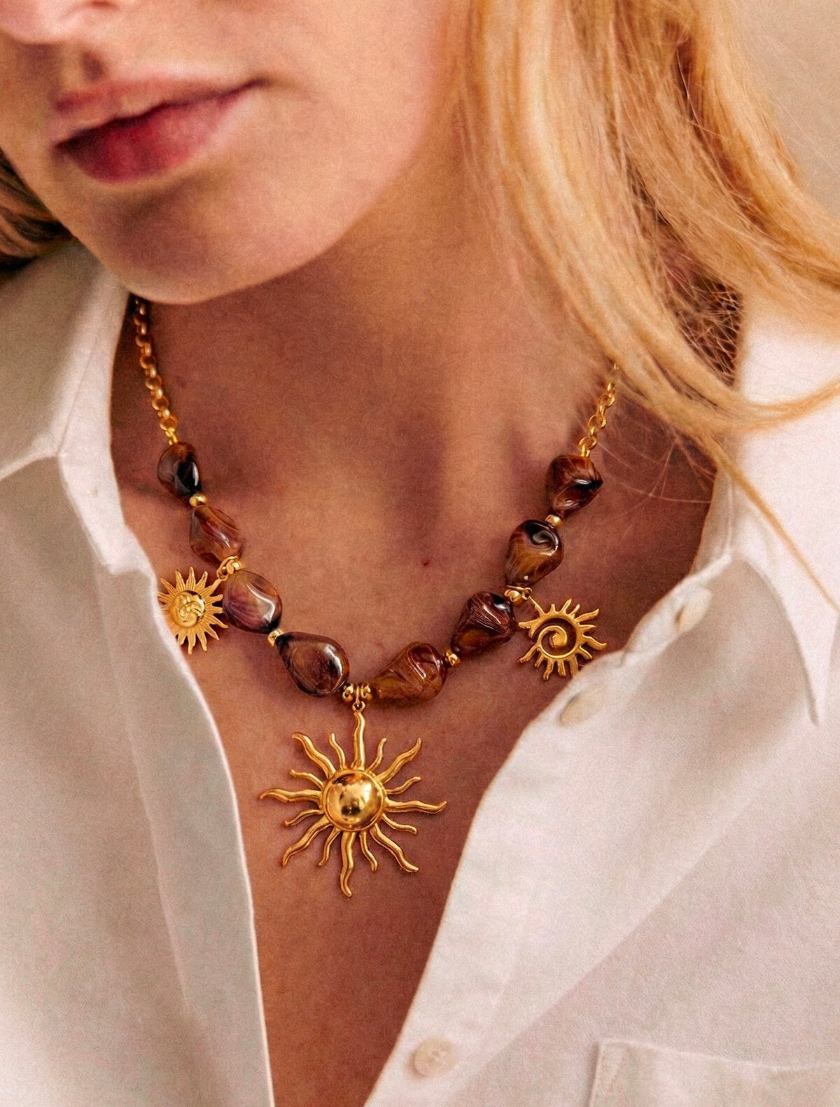 Collier perles résine marbre et breloques soleils dorés
