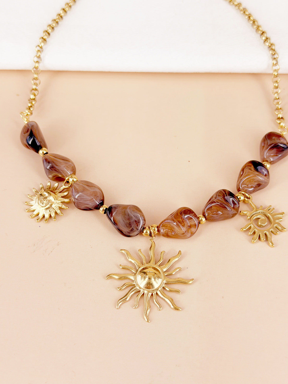 Collier perles résine marbre et breloques soleils dorés