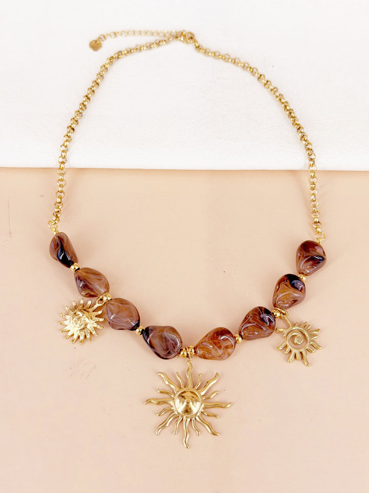Collier perles résine marbre et breloques soleils dorés