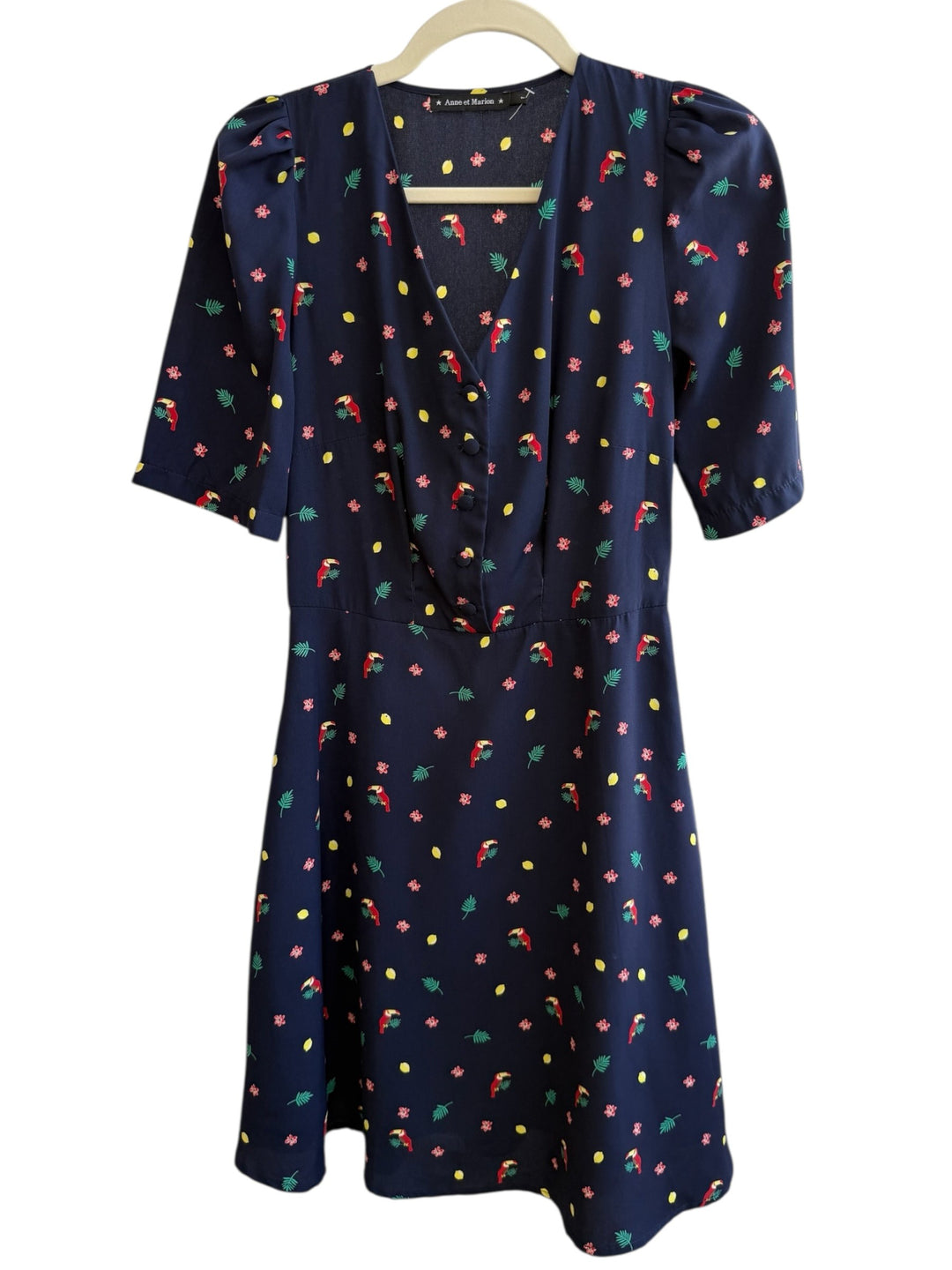 ReTrend navy blue midi dress with toucan, flower, and lemon print. Features V-neck, button front, and puffed sleeves.