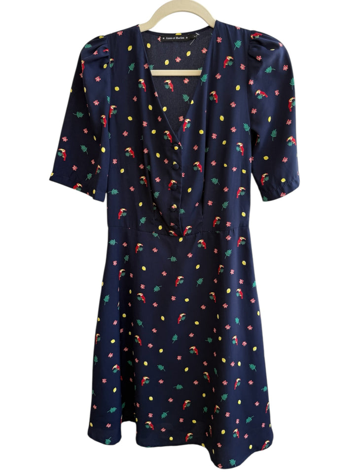 ReTrend navy blue midi dress with toucan, flower, and lemon print. Features V-neck, button front, and puffed sleeves.