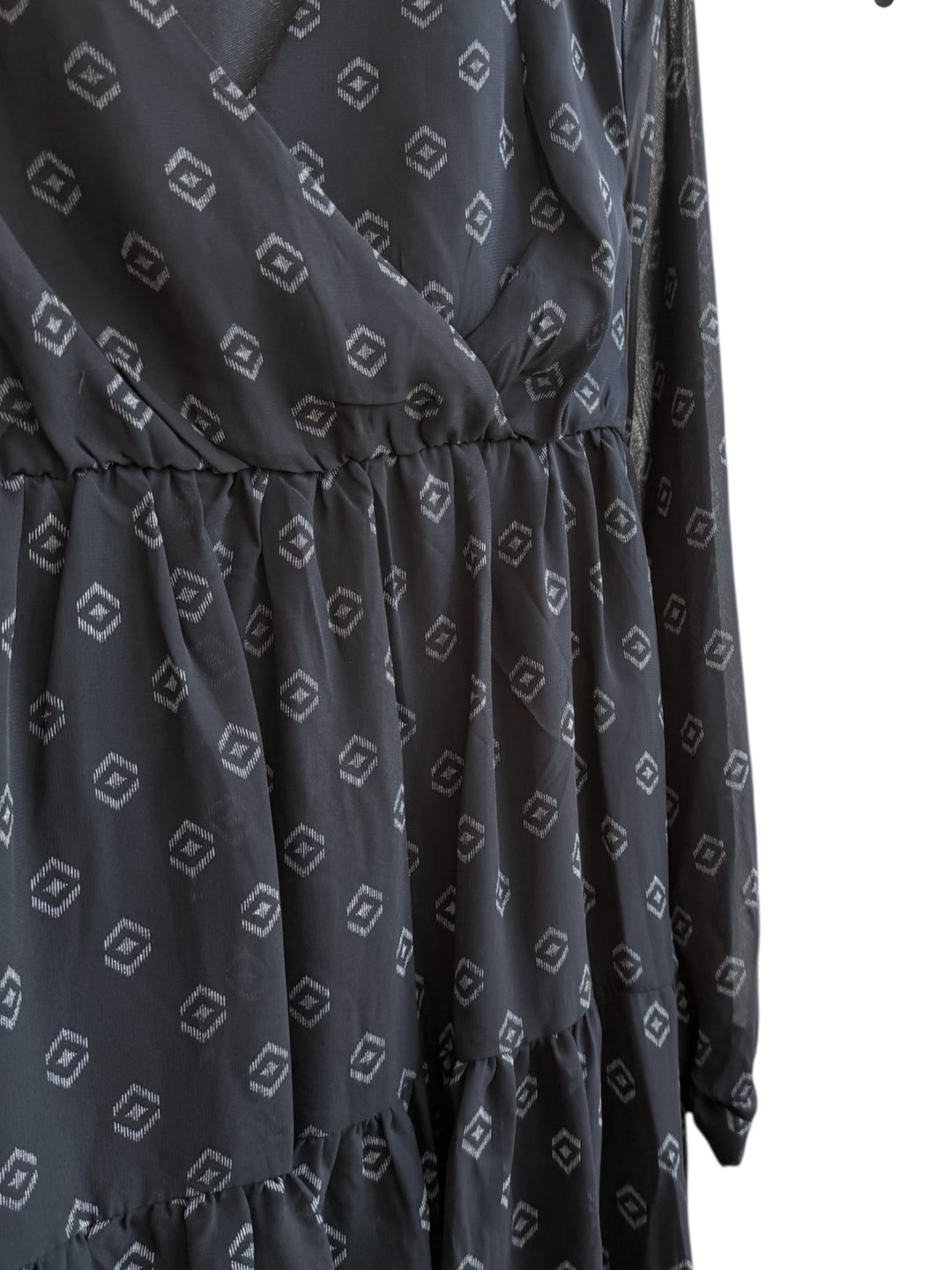 ReTrend black flowy La City dress with subtle geometric print, wrap neckline, and sheer long sleeves. Size 36.