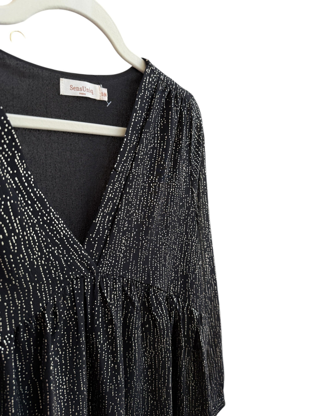 Retrend black fluid dress with subtle gold dotted print, V-neck, empire waist, long sleeves, and ruffled hem. Size S/M.