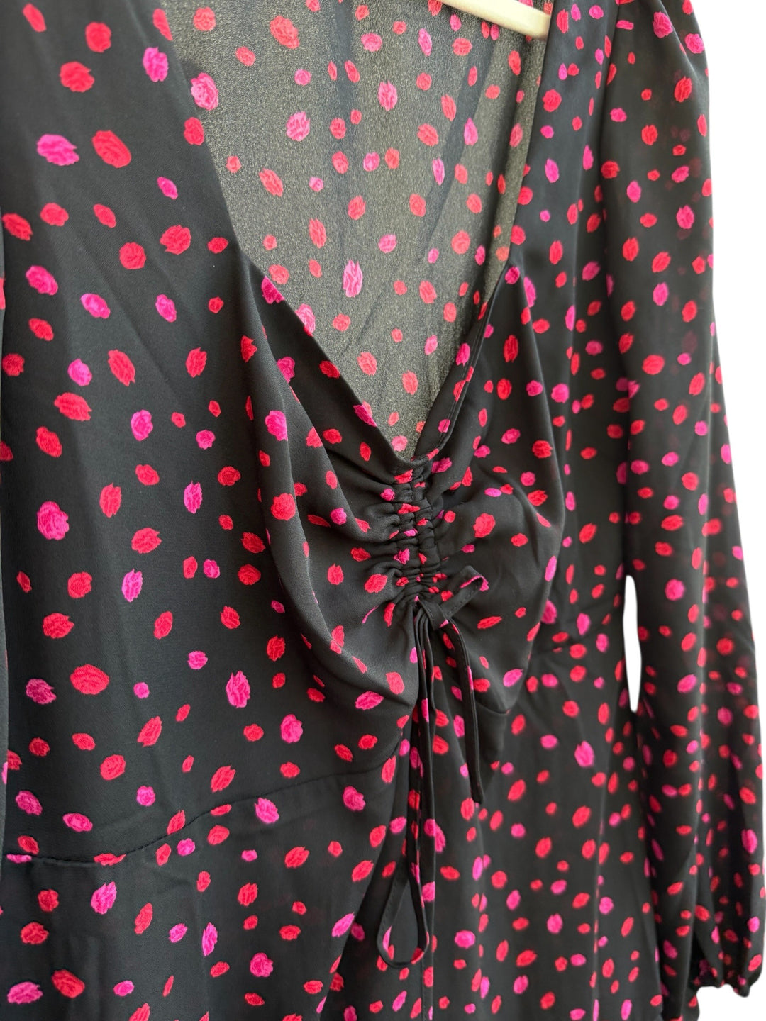 ReTrend black flowing dress with red and pink irregular polka dots, deep V-neck, ruched tie front, long sleeves, and ruffled hem. Size 36.