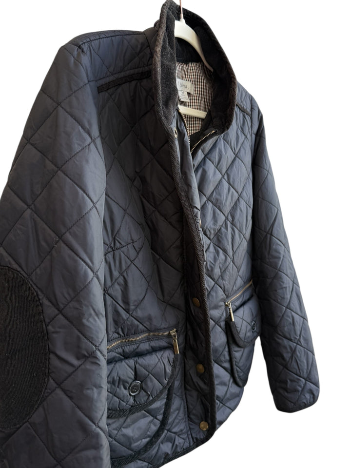 Retrend black quilted jacket, size M, with corduroy collar and elbow patches. Features zip and snap closure, zip pockets, and flap pockets.