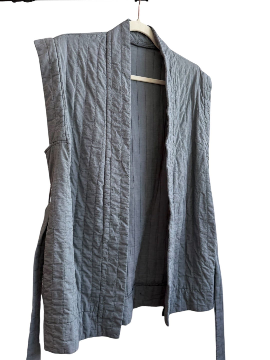 ReTrend grey quilted sleeveless vest with structured cut and tie belt. Ideal for a modern, comfortable look.