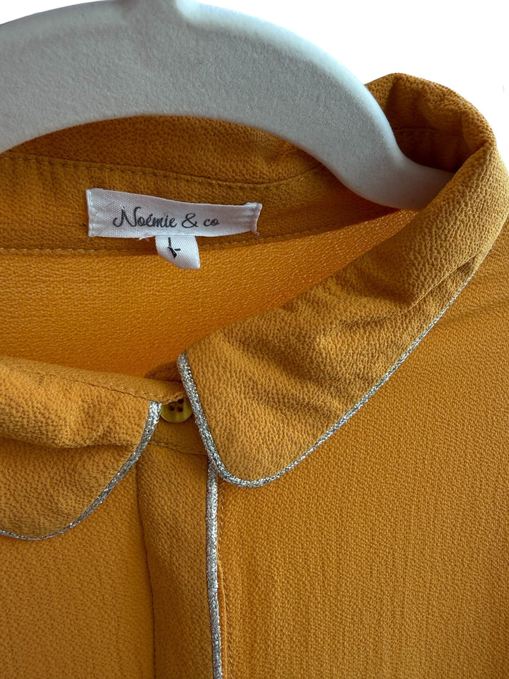 ReTrend mustard yellow polyester blouse with rounded collar and hidden silver trim detail, size L.